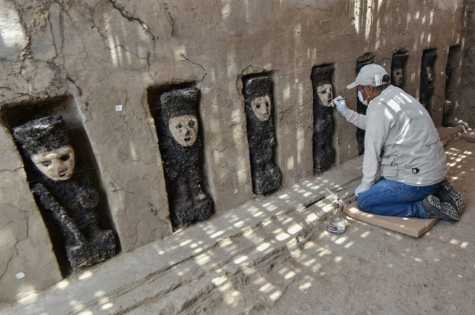 An expert works on excavation of the ceremonial corridor where 20 pre-Columbian wooden statues were found. -- AFP Photo
Viet Nam News
