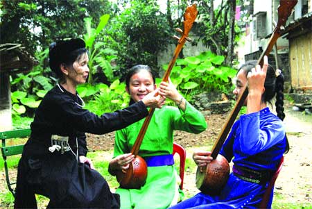 Striking a chord: Schoolgirls at Dinh Hoa High School learn how to play the tinh guitar and sing then folk songs thanks to the careful tutelage of artisan Hoang Thi Bich Hong. Striking a chord: Schoolgirls at Dinh Hoa High School learn how to play the tinh guitar and sing then folk songs thanks to the careful tutelage of artisan Hoang Thi Bich Hong.