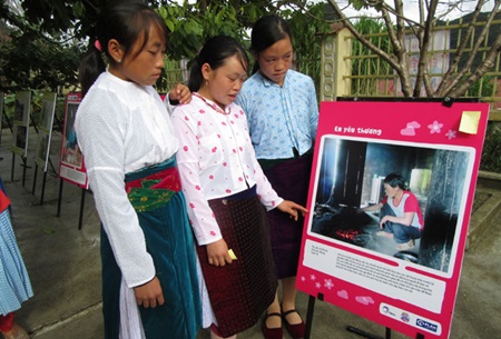 Vu Thi Vu (centre) shows her friends one of her photos on display at Can Chu Phin secondary school in Meo Vac District, Ha Giang Province. Vu Thi Vu (centre) shows her friends one of her photos on display at Can Chu Phin secondary school in Meo Vac District, Ha Giang Province.